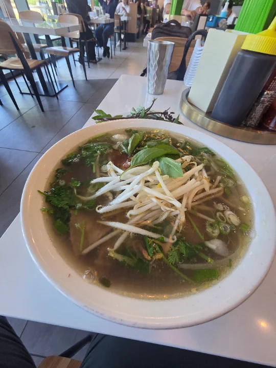 a bowl of pho on a table