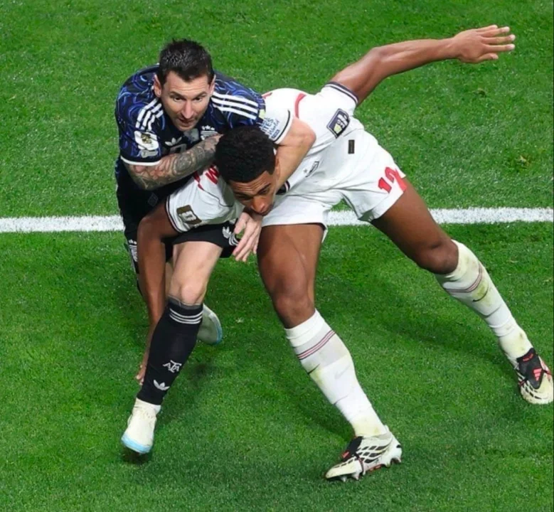 Two soccer players in a physical confrontation on a green field with white lines.
